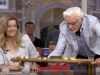 Jan Slagter haalt plank met hapjes van tafel en deelt uit aan het publiek